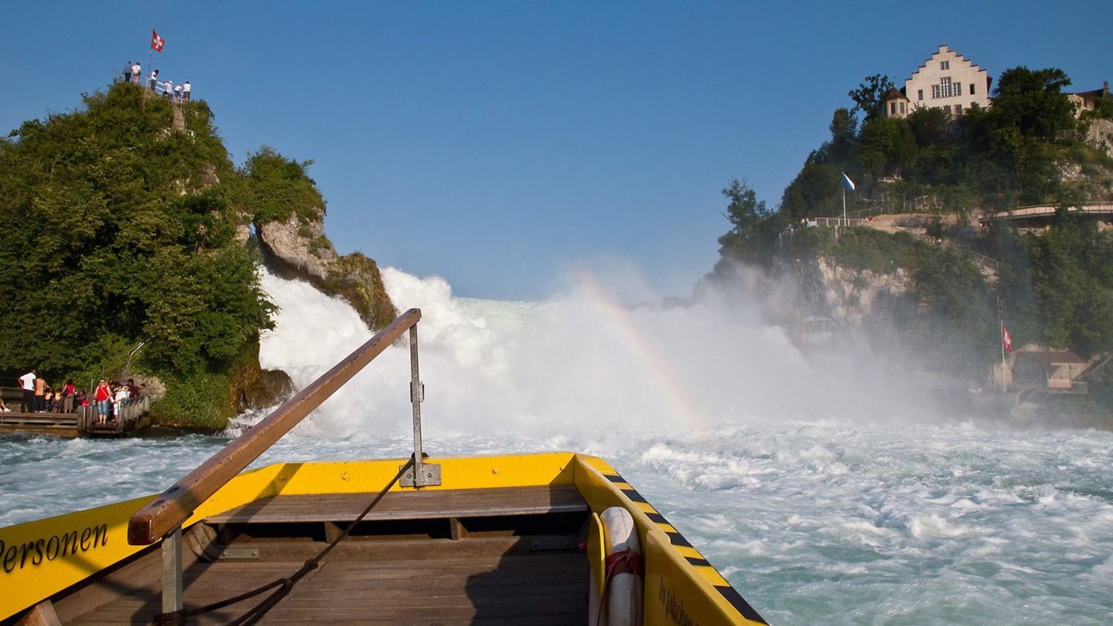 Photo of the cliff standing in the center of the Rhine waterfall from a pleasure boat View of the Rhine waterfall from a pleasure boat