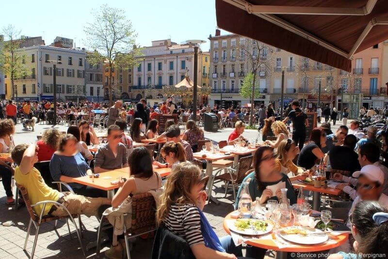 Photo: people in a cafe on the square of Perpignan in France Cafe on the Place de Perpignan