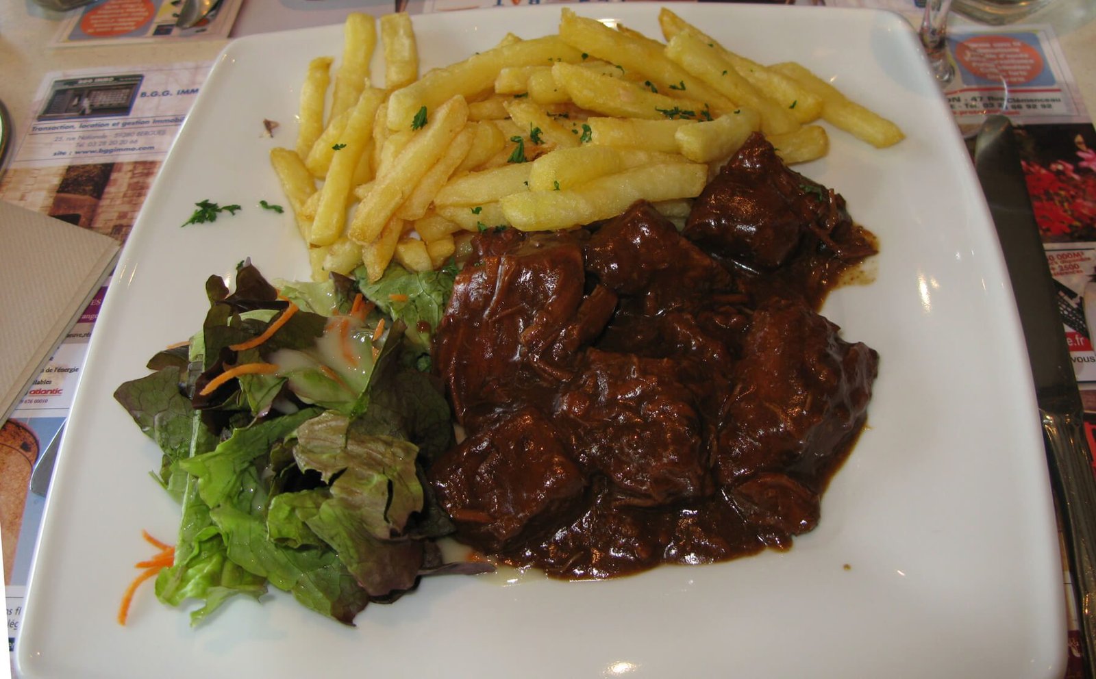 Photo plates with Flemish goulash, French fries and herbs Flemish goulash