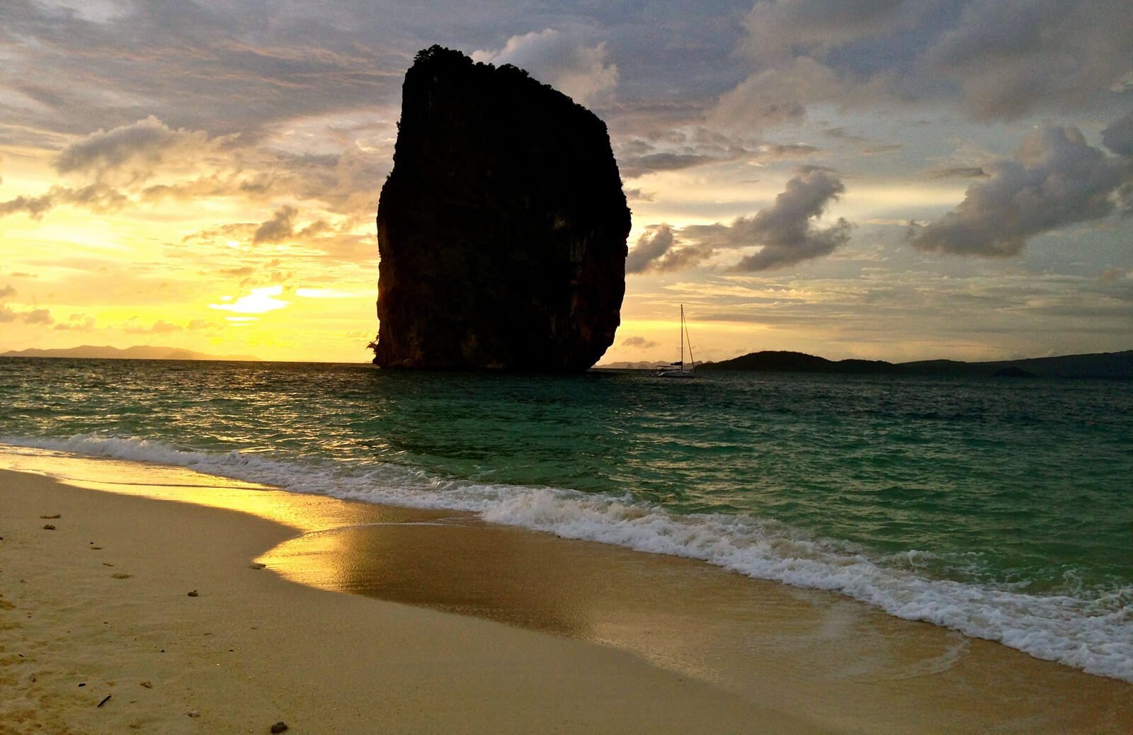Photo of a rock on the background of a sunset on the island of Poda Green Pillar at sunset