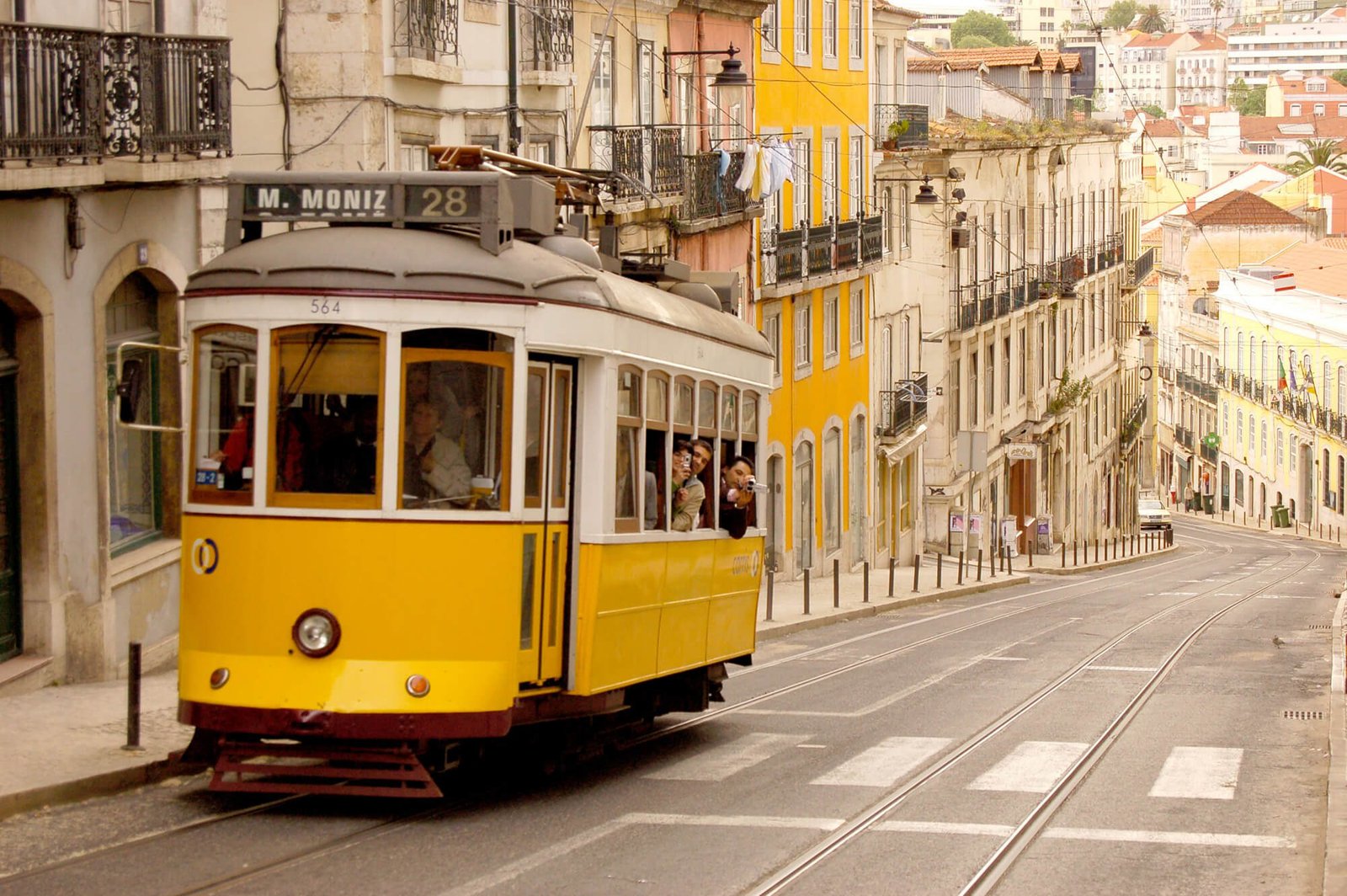 Photo of tram #28 with passengers traveling through the streets of Lisbon Tram No. 28 with passengers, Lisbon