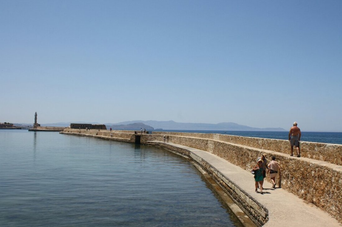 In the photo, the road along the sidewalk along the breakwaters to the lighthouse of Chania How to get to the lighthouse of Chania