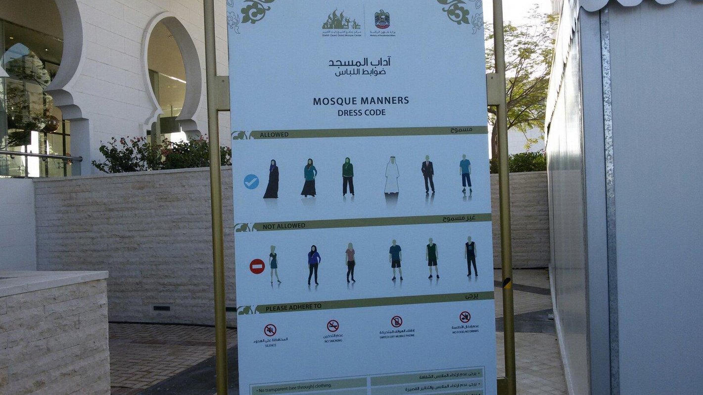 Dress code information sign at the entrance of Sheikh Zayed Mosque in Abu Dhabi Dress code for entering the White Mosque in Abu Dhabi