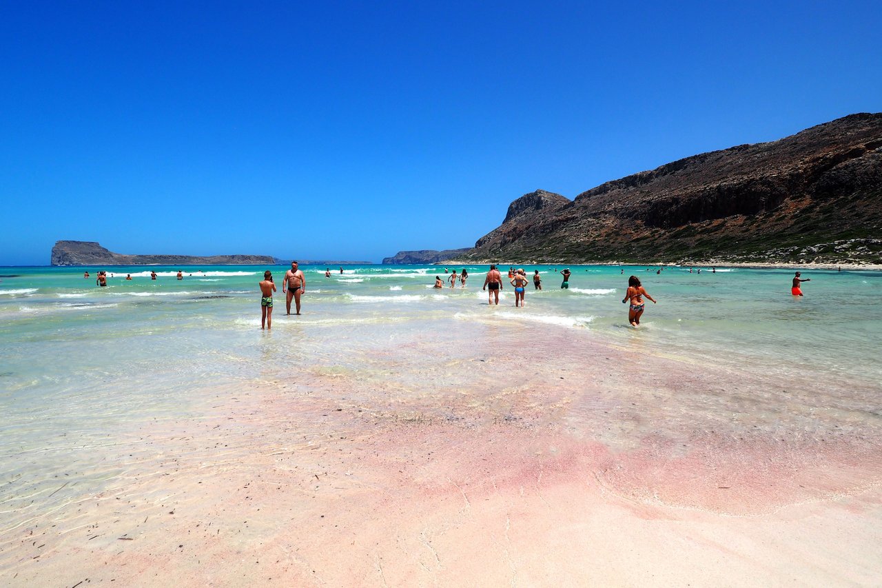 Pink shade of Balos Bay beach The shore and bottom of the bay are covered with white sand