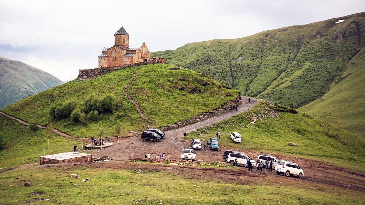 Photos of cars at the foot of the mountain At the foot of the mountain there are taxi drivers and cars of Kazbegi residents