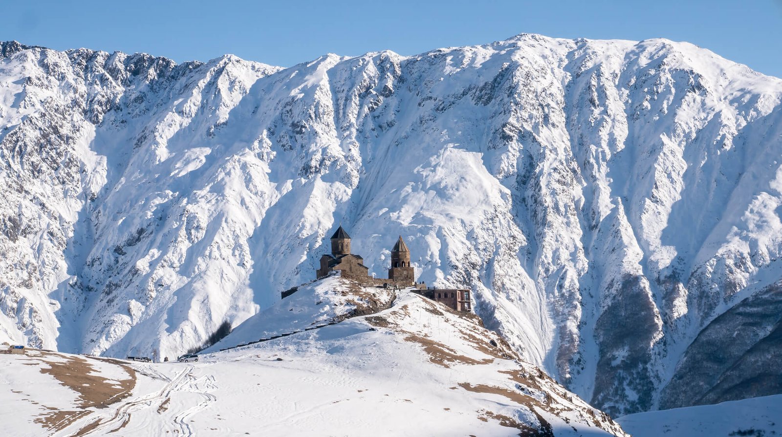 Photo of the Gergeti church under Mount Kazbek in winter Gergeti Church in winter in Stepantsminda