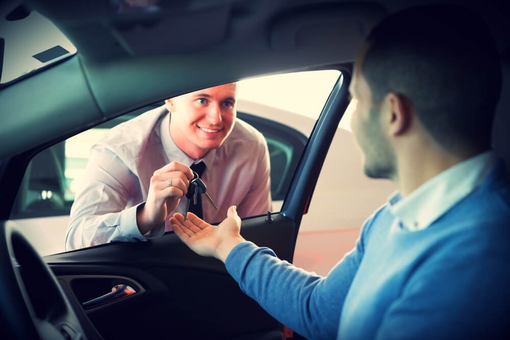 A man passes the keys to another man Rent a car