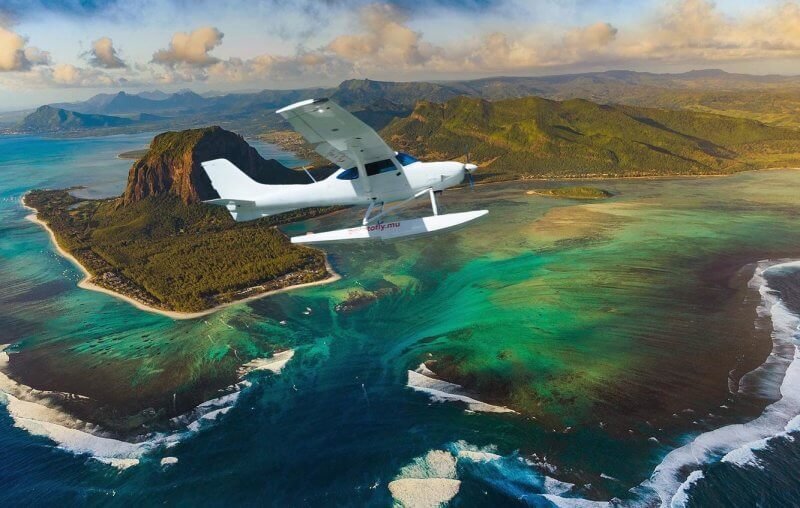 Air travel to Mauritius An airplane in front of a mountain and an underwater waterfall