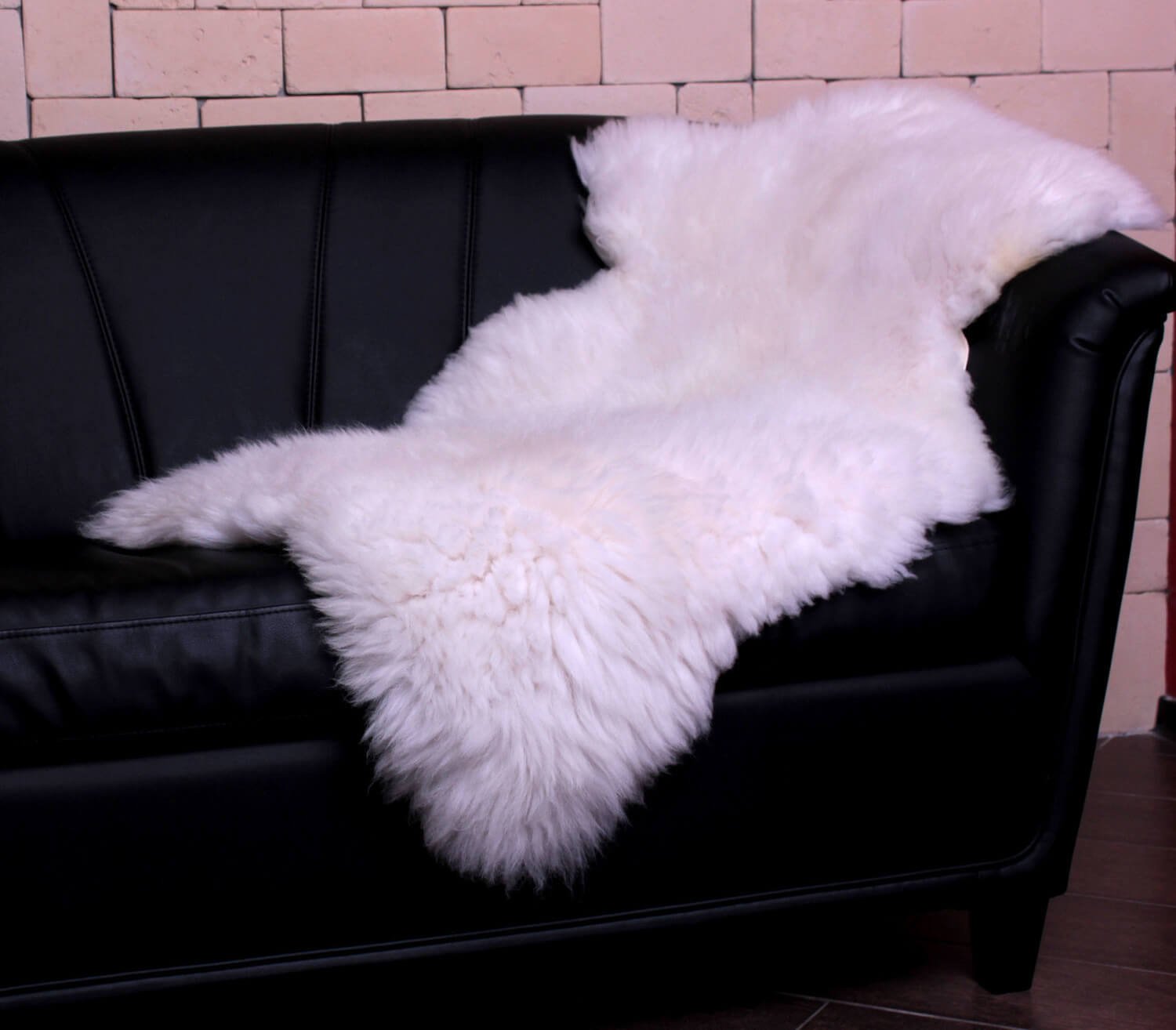 A white sheepskin on a black sofa Sheepskin
