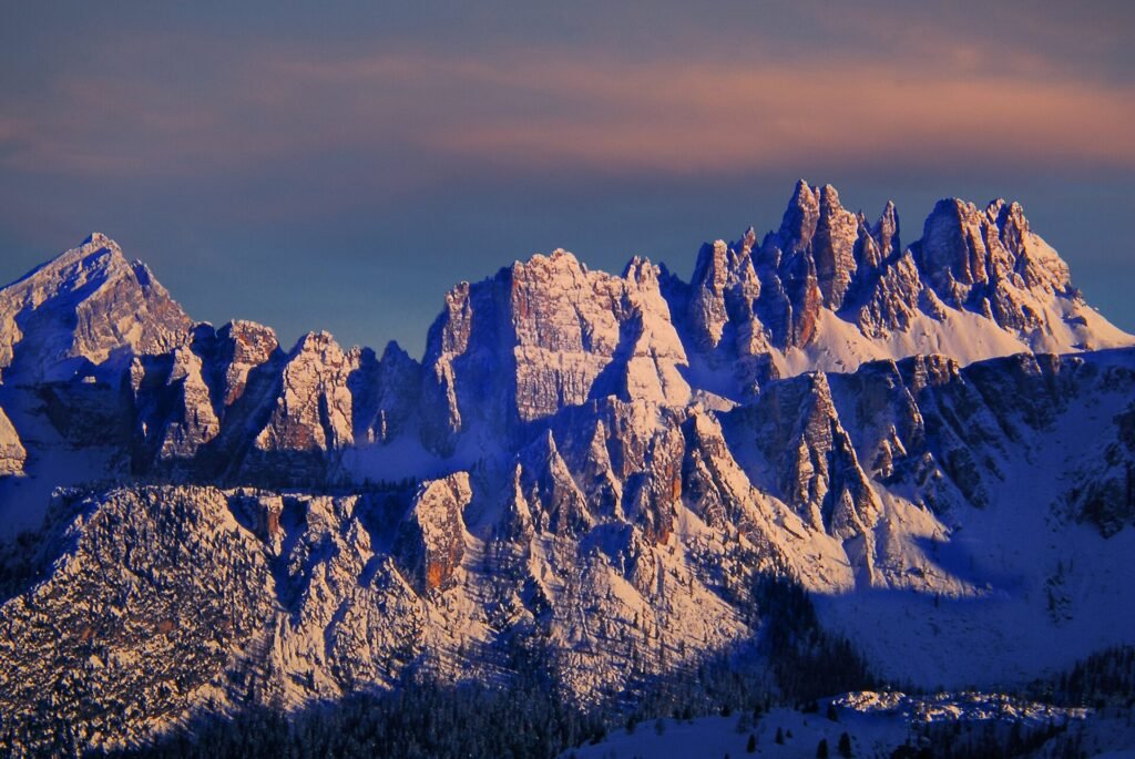 Snow-covered Dolomite peaks above Cortina d'Ampezzo glowing pink in the winter evening light