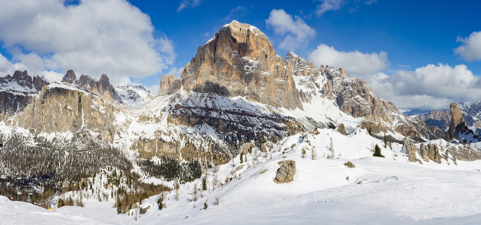 Tofana di Rozes rising above snowy slopes and forest near Cortina d'Ampezzo